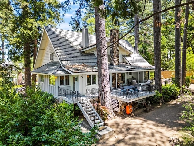 27833 Hamiltair Dr, Lake Arrowhead, CA 92352 - view of front facade featuring a chimney, board and batten siding, stairway, and covered porch