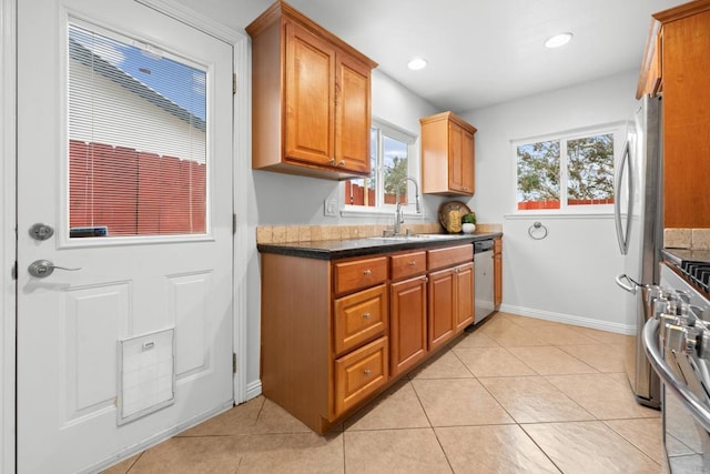 1409 Taft St, Escondido, CA 92026 - kitchen featuring stainless steel appliances, baseboards, a sink, dark countertops, and light tile patterned flooring
