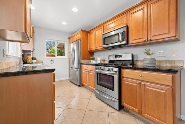 1409 Taft St, Escondido, CA 92026 - kitchen with appliances with stainless steel finishes, a sink, light tile patterned floors, baseboards, and brown cabinetry
