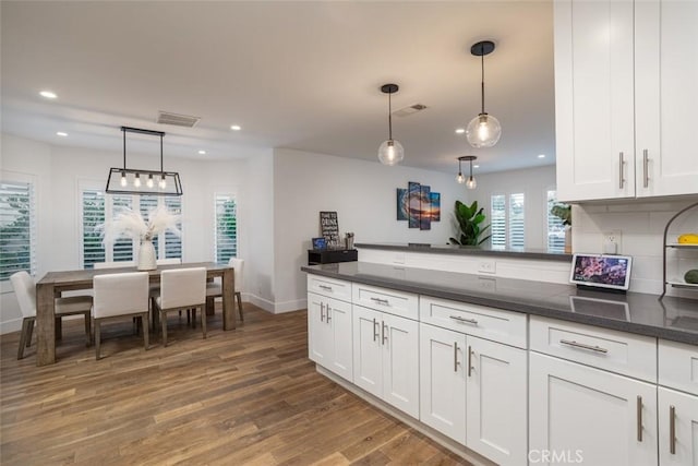 1792 Kenwood Pl, Costa Mesa, CA 92627 - kitchen featuring wood finished floors, recessed lighting, white cabinets, hanging light fixtures, and a peninsula