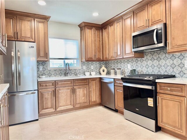 610 N Northwood Ave, Compton, CA 90220 - kitchen with stainless steel appliances, brown cabinets, light countertops, decorative backsplash, and recessed lighting