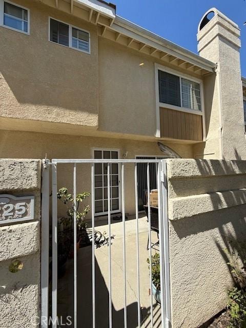 5225 Columbus Pl, Oxnard, CA 93033 - view of exterior entry with stucco siding and a chimney