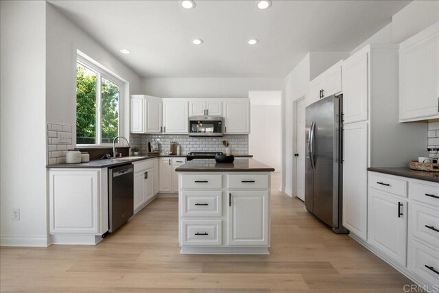 29589 Hazel Glen Rd, Murrieta, CA 92563 - kitchen featuring stainless steel appliances, dark countertops, a kitchen island, tasteful backsplash, and recessed lighting