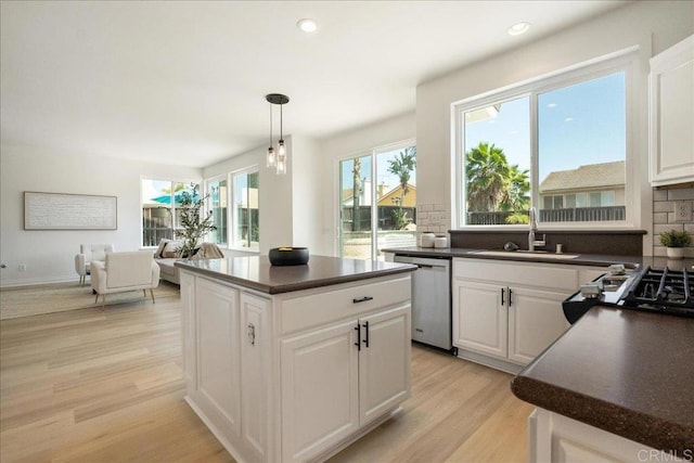 29589 Hazel Glen Rd, Murrieta, CA 92563 - kitchen featuring stainless steel dishwasher, dark countertops, light wood-style flooring, white cabinetry, and recessed lighting