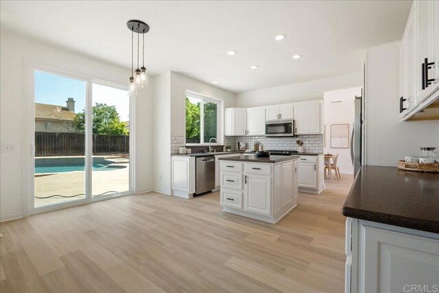 29589 Hazel Glen Rd, Murrieta, CA 92563 - kitchen with stainless steel appliances, dark countertops, a kitchen island, tasteful backsplash, and recessed lighting