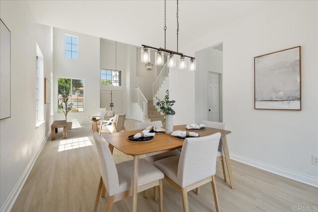 29589 Hazel Glen Rd, Murrieta, CA 92563 - dining area with light wood-style floors, stairs, and a high ceiling