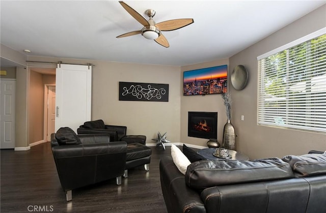 38919 Hickory Hill Ct, Murrieta, CA 92563 - living area featuring a ceiling fan, dark wood-type flooring, a warm lit fireplace, and a barn door