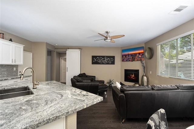38919 Hickory Hill Ct, Murrieta, CA 92563 - living room with a ceiling fan, dark wood-style flooring, and a warm lit fireplace