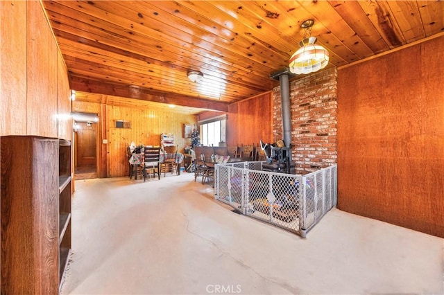 56225 Moonstone Ln, Yucca Valley, CA 92284 - living room with wooden walls, a wood stove, wood ceiling, and concrete flooring