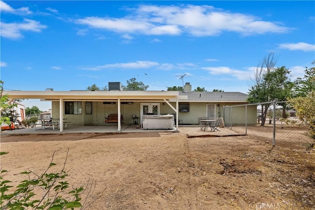 9614 Peach Ave, Hesperia, CA 92345 - rear view of house featuring a patio area, a hot tub, and a chimney
