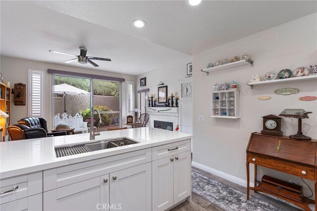 2141 Triador St Unit 103, Corona, CA 92879 - kitchen with a sink, light countertops, ceiling fan, white cabinets, and light wood-type flooring