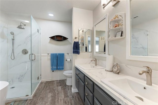2141 Triador St Unit 103, Corona, CA 92879 - bathroom with a marble finish shower, double vanity, wood finished floors, and toilet