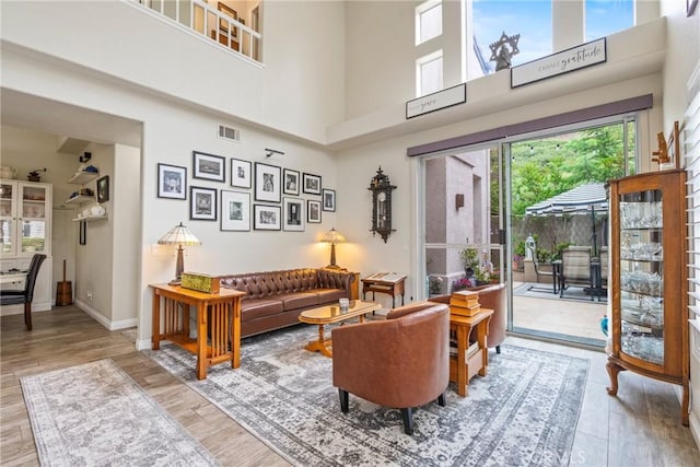 2141 Triador St Unit 103, Corona, CA 92879 - living room featuring a towering ceiling, wood finished floors, and baseboards