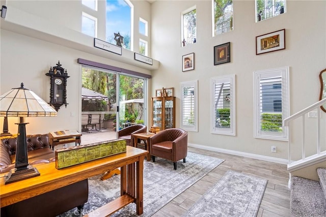 2141 Triador St Unit 103, Corona, CA 92879 - living area featuring stairway, baseboards, wood finished floors, and a high ceiling