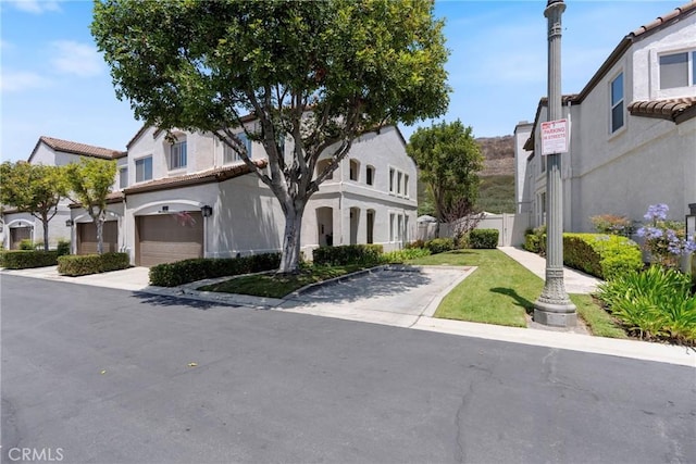 2141 Triador St Unit 103, Corona, CA 92879 - view of property with a garage, driveway, stucco siding, and a tiled roof