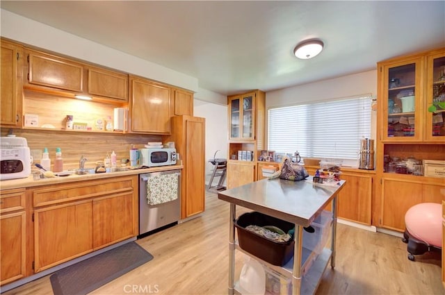 866 Brighton Ave, Grover Beach, CA 93433 - kitchen with dishwasher, light wood-style flooring, light countertops, brown cabinetry, and glass insert cabinets