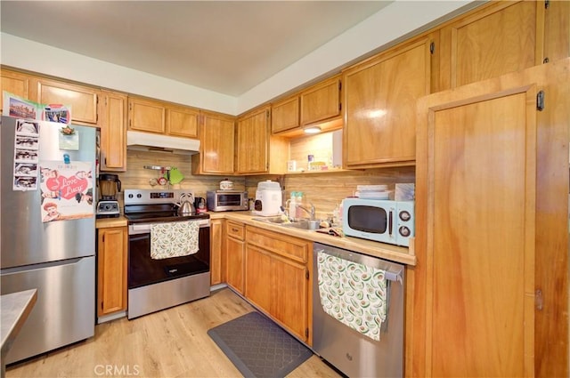 866 Brighton Ave, Grover Beach, CA 93433 - kitchen featuring stainless steel appliances, under cabinet range hood, a sink, light countertops, and light wood finished floors