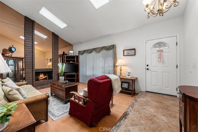 20121 Swansea Ln, Huntington Beach, CA 92646 - living area featuring a fireplace, vaulted ceiling, a chandelier, and light wood finished floors
