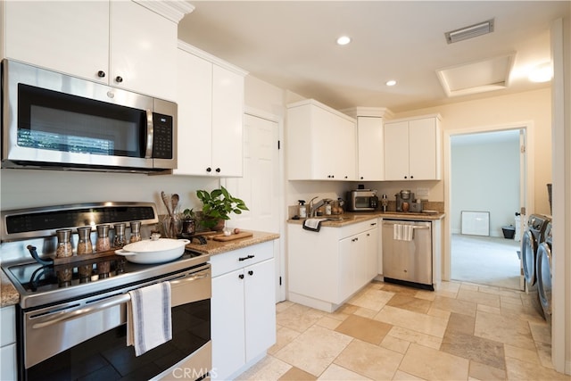 23538 Arlen Dr, Newhall, CA 91321 - kitchen featuring appliances with stainless steel finishes, independent washer and dryer, white cabinetry, recessed lighting, and light stone counters