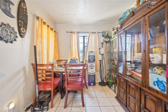 11100 S Normandie Ave, Los Angeles, CA 90044 - dining space featuring light tile patterned floors and a textured ceiling