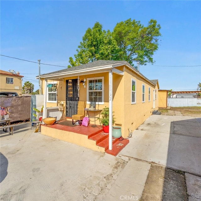 11100 S Normandie Ave, Los Angeles, CA 90044 - bungalow-style house featuring stucco siding, a porch, and a patio area