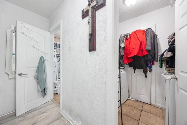 11100 S Normandie Ave, Los Angeles, CA 90044 - corridor featuring a textured ceiling, a textured wall, and independent washer and dryer