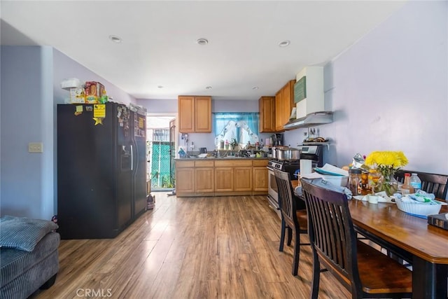 11100 S Normandie Ave, Los Angeles, CA 90044 - kitchen with black fridge, light wood-style floors, and stainless steel range with gas cooktop