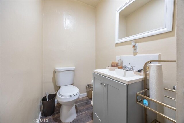 11100 S Normandie Ave, Los Angeles, CA 90044 - bathroom with toilet, vanity, wood finished floors, and baseboards