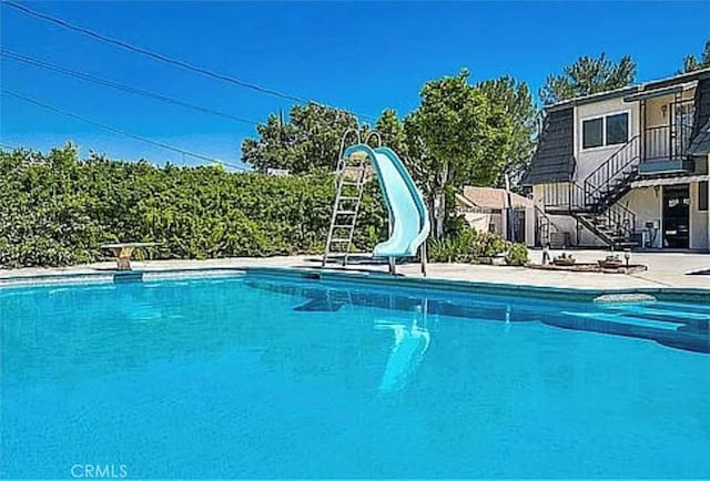 564 Northpark Blvd, San Bernardino, CA 92407 - view of swimming pool featuring a water slide, stairs, and a patio