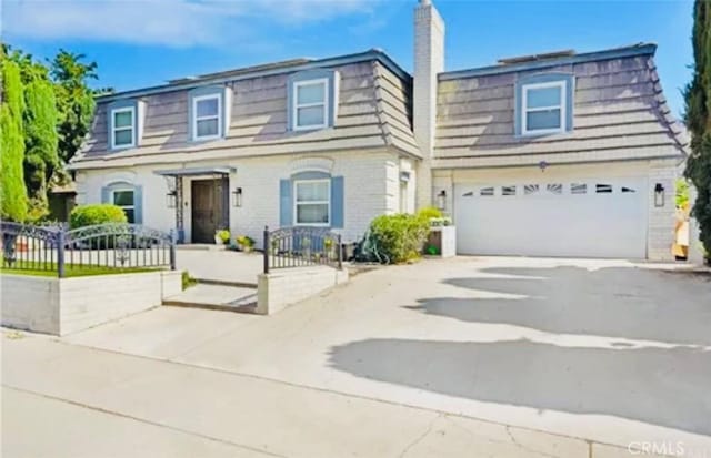 564 Northpark Blvd, San Bernardino, CA 92407 - view of front of house featuring driveway, mansard roof, a chimney, and a garage