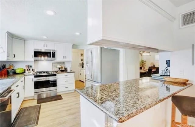 564 Northpark Blvd, San Bernardino, CA 92407 - kitchen featuring appliances with stainless steel finishes, light wood-style floors, light stone counters, recessed lighting, and a towering ceiling