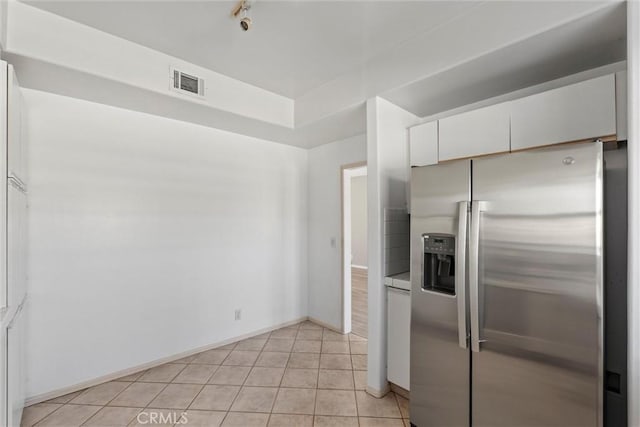10925 Blix St Unit 309, Toluca Lake, CA 91602 - kitchen featuring stainless steel refrigerator with ice dispenser, white cabinetry, light tile patterned floors, and baseboards