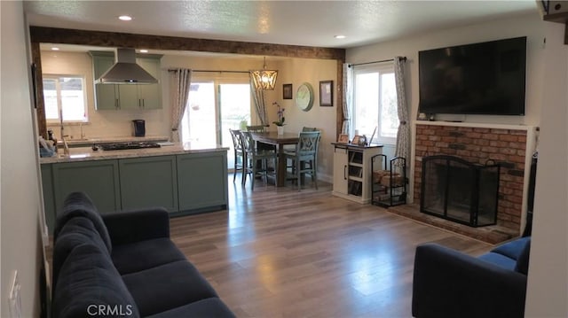 6214 Granby Ave, Rancho Cucamonga, CA 91737 - living area featuring wood finished floors, plenty of natural light, a brick fireplace, and recessed lighting