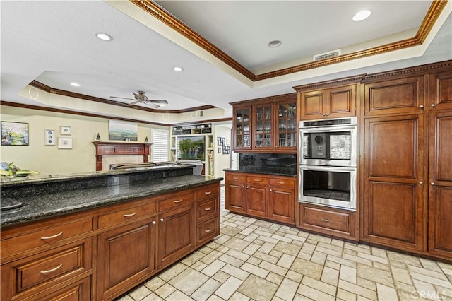 28642 Apricot Pl, Saugus, CA 91390 - kitchen featuring a tray ceiling, double oven, crown molding, a ceiling fan, and glass insert cabinets