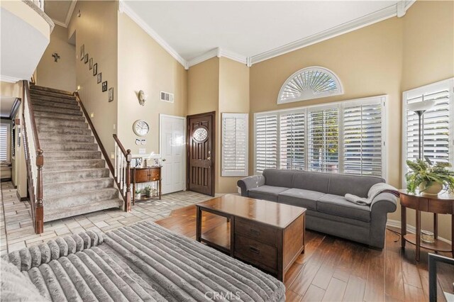 28642 Apricot Pl, Saugus, CA 91390 - living area featuring a towering ceiling, stairs, crown molding, baseboards, and wood finished floors