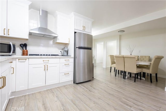 3720 S St Andrews Pl, Los Angeles, CA 90018 - kitchen featuring stainless steel appliances, wall chimney exhaust hood, backsplash, light countertops, and white cabinetry