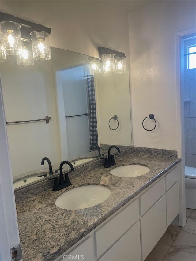 8505 Columbus Ave Unit 316, North Hills, CA 91343 - full bath featuring double vanity, toilet, and marble look tile flooring
