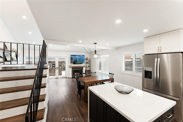 2191 Canyon Unit C103, Costa Mesa, CA 92627 - kitchen featuring stainless steel fridge, open floor plan, recessed lighting, white cabinets, and a lit fireplace