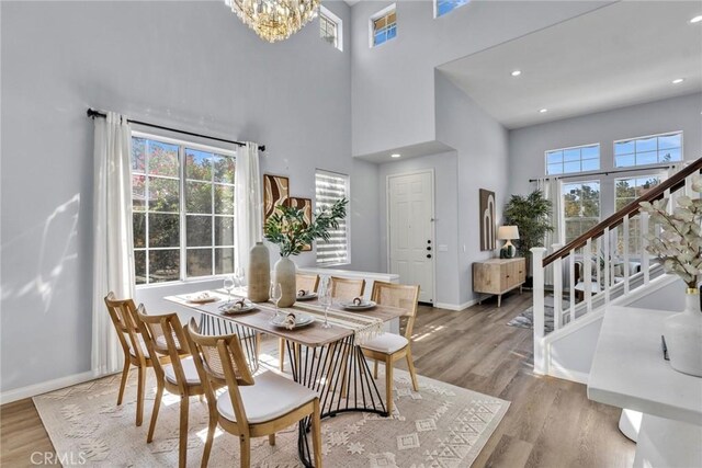 11376 Starlight Dr, Rancho Cucamonga, CA 91701 - dining space with a towering ceiling, light wood-type flooring, a chandelier, stairs, and recessed lighting