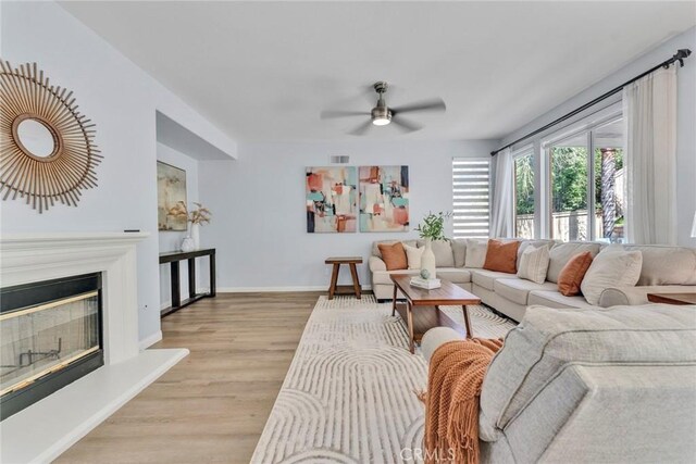 11376 Starlight Dr, Rancho Cucamonga, CA 91701 - living room with a ceiling fan, light wood-type flooring, and a glass covered fireplace