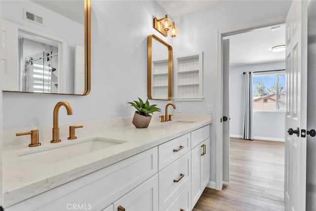 11376 Starlight Dr, Rancho Cucamonga, CA 91701 - full bath featuring double vanity, wood finished floors, and a shower with shower door