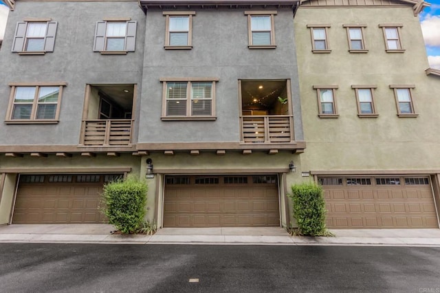 1003 Overton Ct, Tustin, CA 92780 - view of front facade with stucco siding, a balcony, and an attached garage