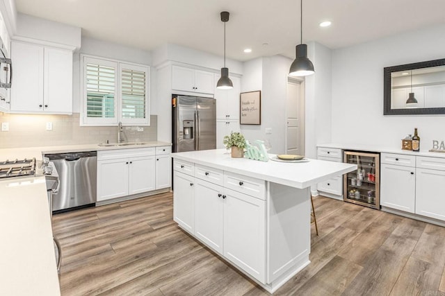 1003 Overton Ct, Tustin, CA 92780 - kitchen featuring wine cooler, appliances with stainless steel finishes, a sink, light wood-style flooring, and recessed lighting