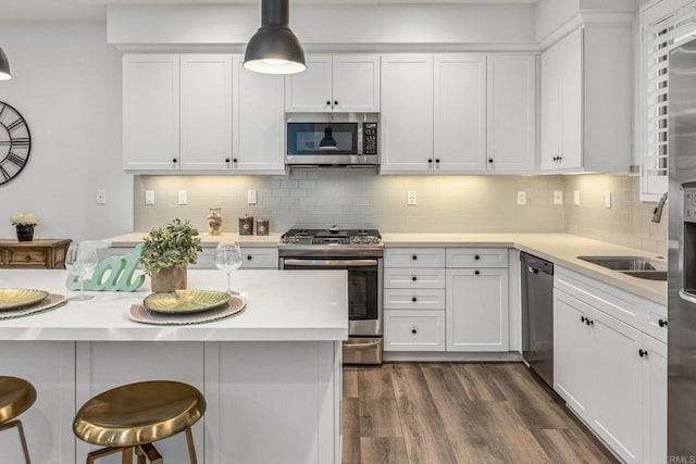 1003 Overton Ct, Tustin, CA 92780 - kitchen with appliances with stainless steel finishes, a kitchen breakfast bar, white cabinetry, and light countertops