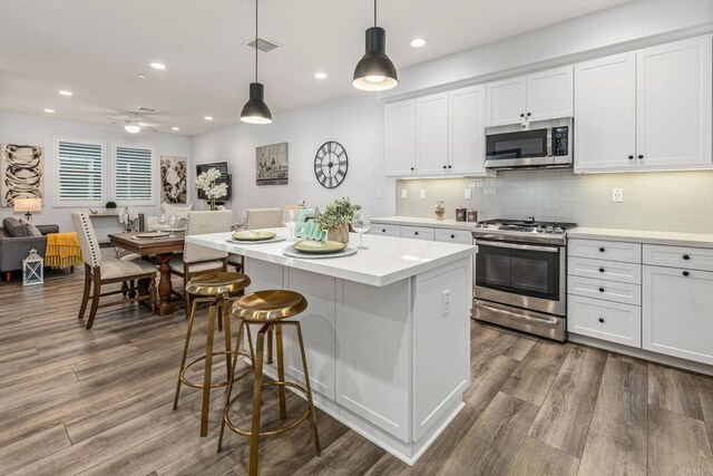 1003 Overton Ct, Tustin, CA 92780 - kitchen with stainless steel appliances, dark wood-type flooring, white cabinetry, and recessed lighting