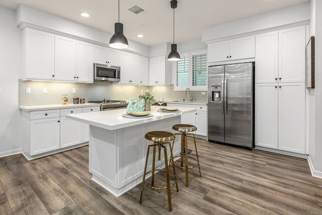 1003 Overton Ct, Tustin, CA 92780 - kitchen featuring appliances with stainless steel finishes, dark wood finished floors, white cabinetry, and recessed lighting