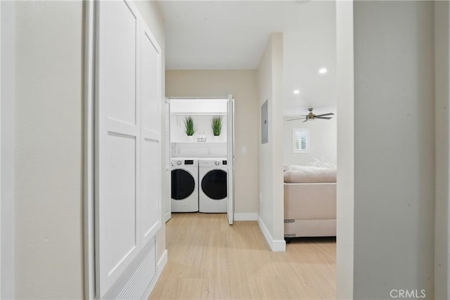 1217 W 77th St, Los Angeles, CA 90044 - laundry area with washing machine and dryer, electric panel, light wood finished floors, ceiling fan, and baseboards
