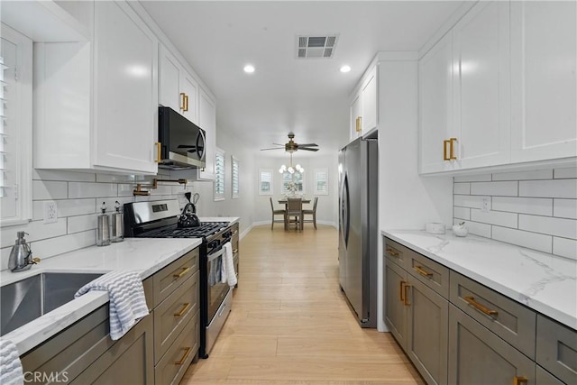 1217 W 77th St, Los Angeles, CA 90044 - kitchen with appliances with stainless steel finishes, recessed lighting, light wood-style flooring, white cabinets, and decorative backsplash