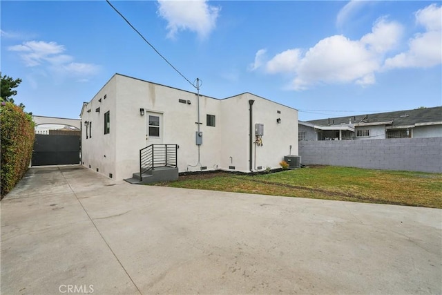 1217 W 77th St, Los Angeles, CA 90044 - rear view of property featuring stucco siding, driveway, central air condition unit, and a patio