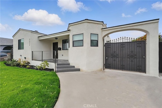 1217 W 77th St, Los Angeles, CA 90044 - view of front of property featuring a front yard, stucco siding, and a gate